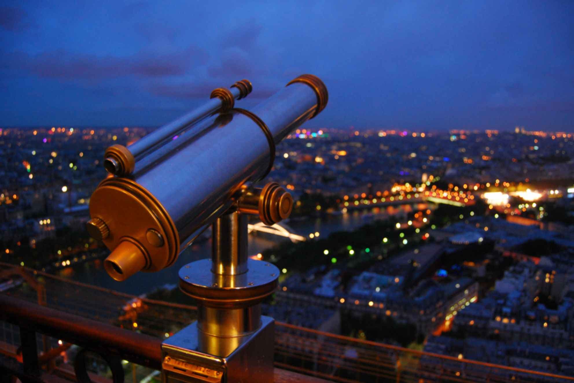 Aussichtsfernrohr mit Blick über das nächtliche Paris