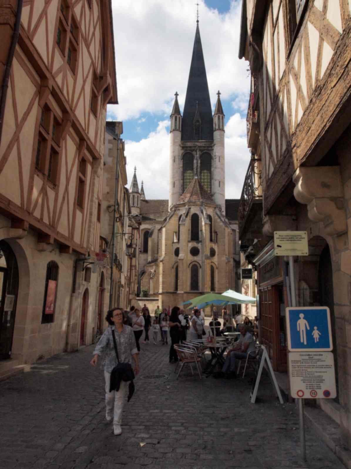 Blick auf den Kirchturm in einer Kopfsteinpflastergasse